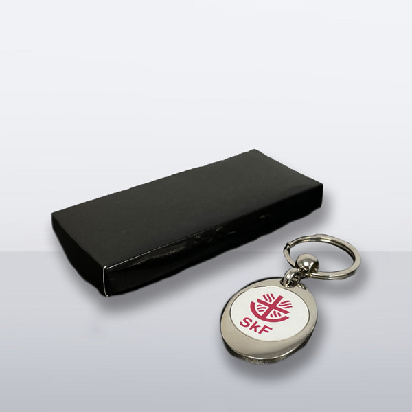 Schlüsselanhänger mit herausnehmbarem Einkaufschip und SkF-Logo, verpackt in edler schwarzer Geschenkbox