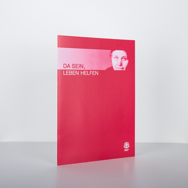 Rote Einlegemappe mit der Aufschrift „Da sein leben helfen" und dem Porträt einer Frau