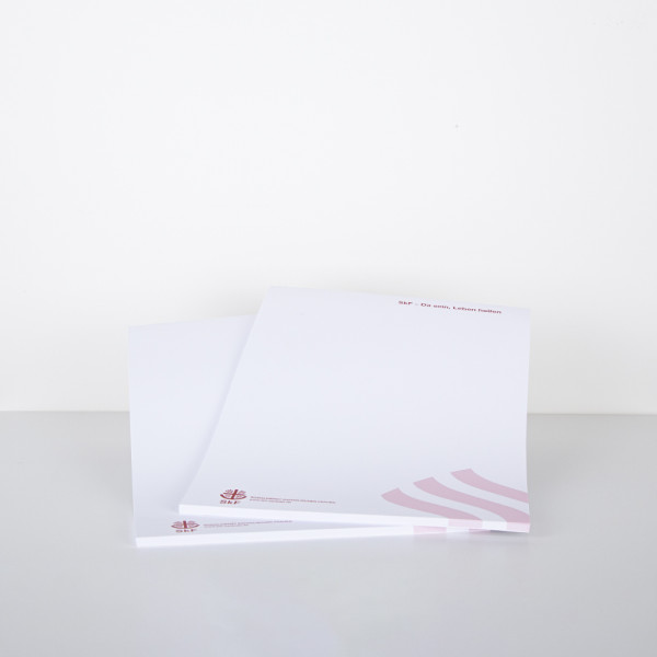 Schreibblock im DIN-A4-Format mit SkF-Logo und dezentem grafischen Element in rot am unteren Rand