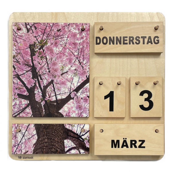 Holzkalender mit wechselbaren Plättchen für Wochentage, Datum, Monat und Jahreszeit. Zwei Naturfotos, die zusammen ein Gesamtbild ergeben. Blühender Baum von unten fotografiert