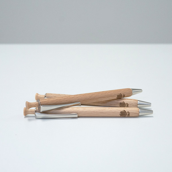 Drei Holz-Kugelschreiber mit Metallclip und SkF-Logo liegen übereinander