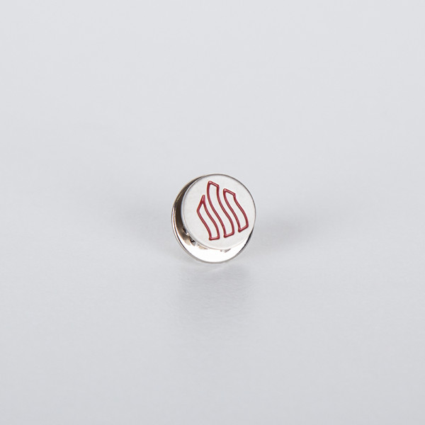 Runde silberne Anstecknadel mit einem roten Symbol aus dem SkF-Logo auf weißem Hintergrund